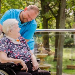 Pfleger und Frau im Rollstuhl