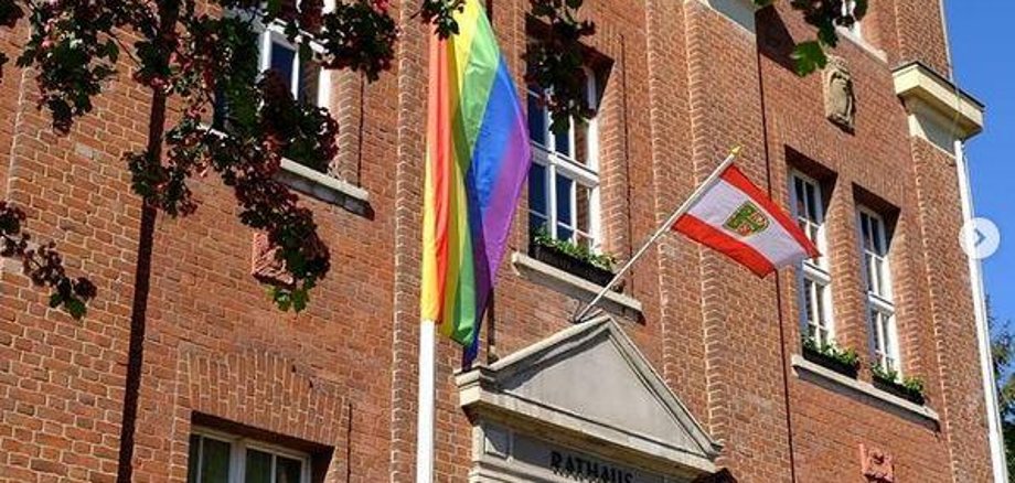 Bürgermeisterin und Gleichstellungsbeauftragte hissen Regenbogenflagge am Rathaus